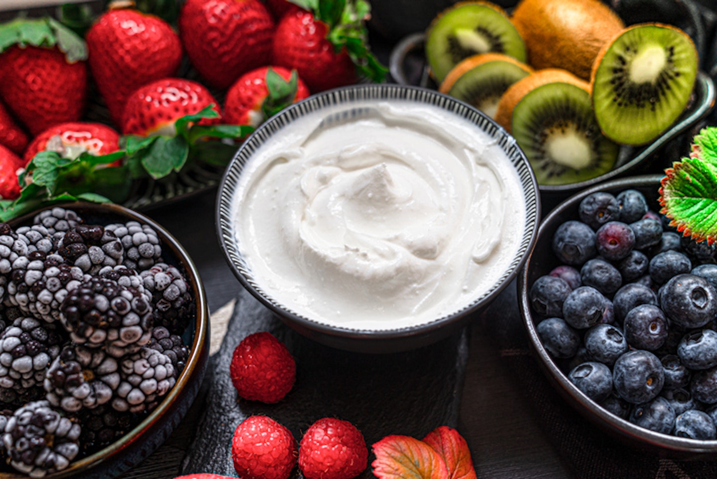 Greek yogurt in a glass jars with spoons,Healthy breakfast with Fresh greek yogurt, muesli and berries on background.