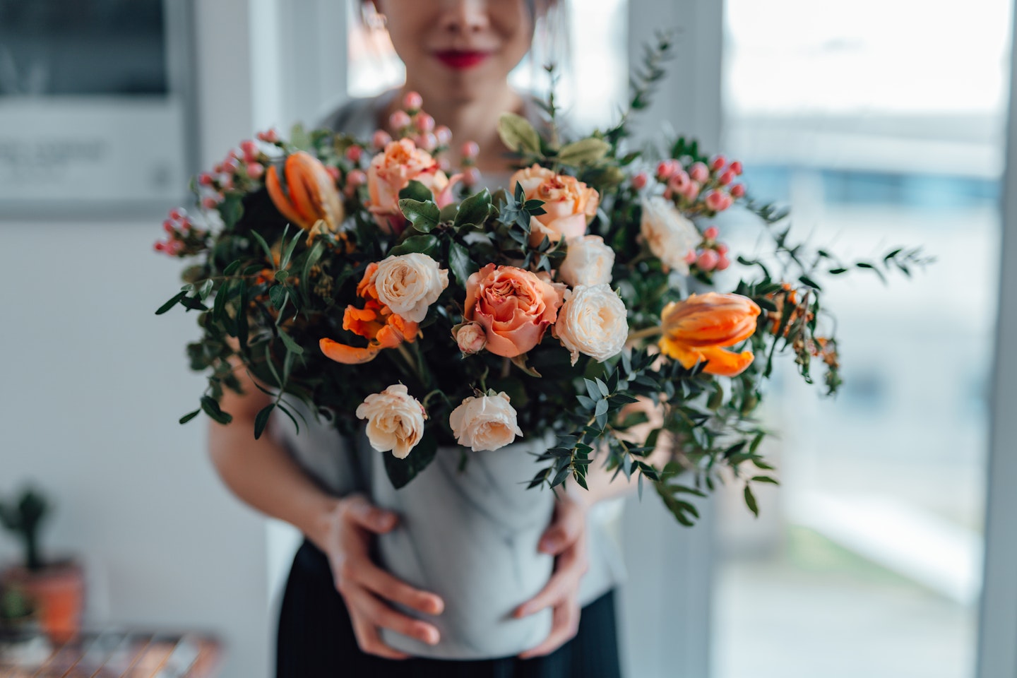 Woman holding a vase of flowers