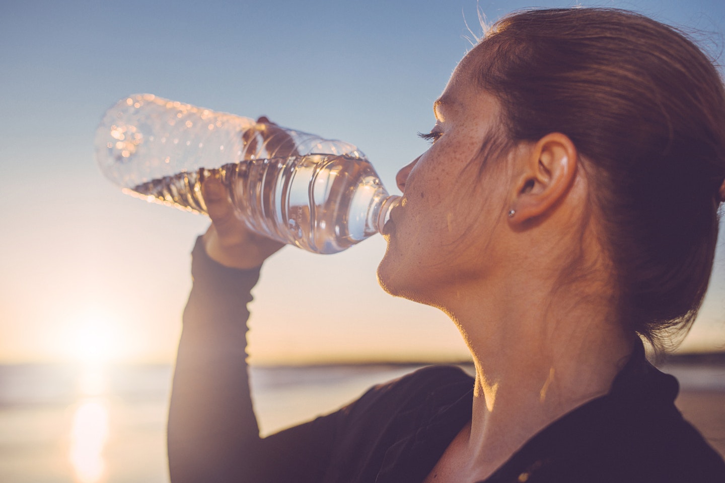 woman drinking water from a bottle