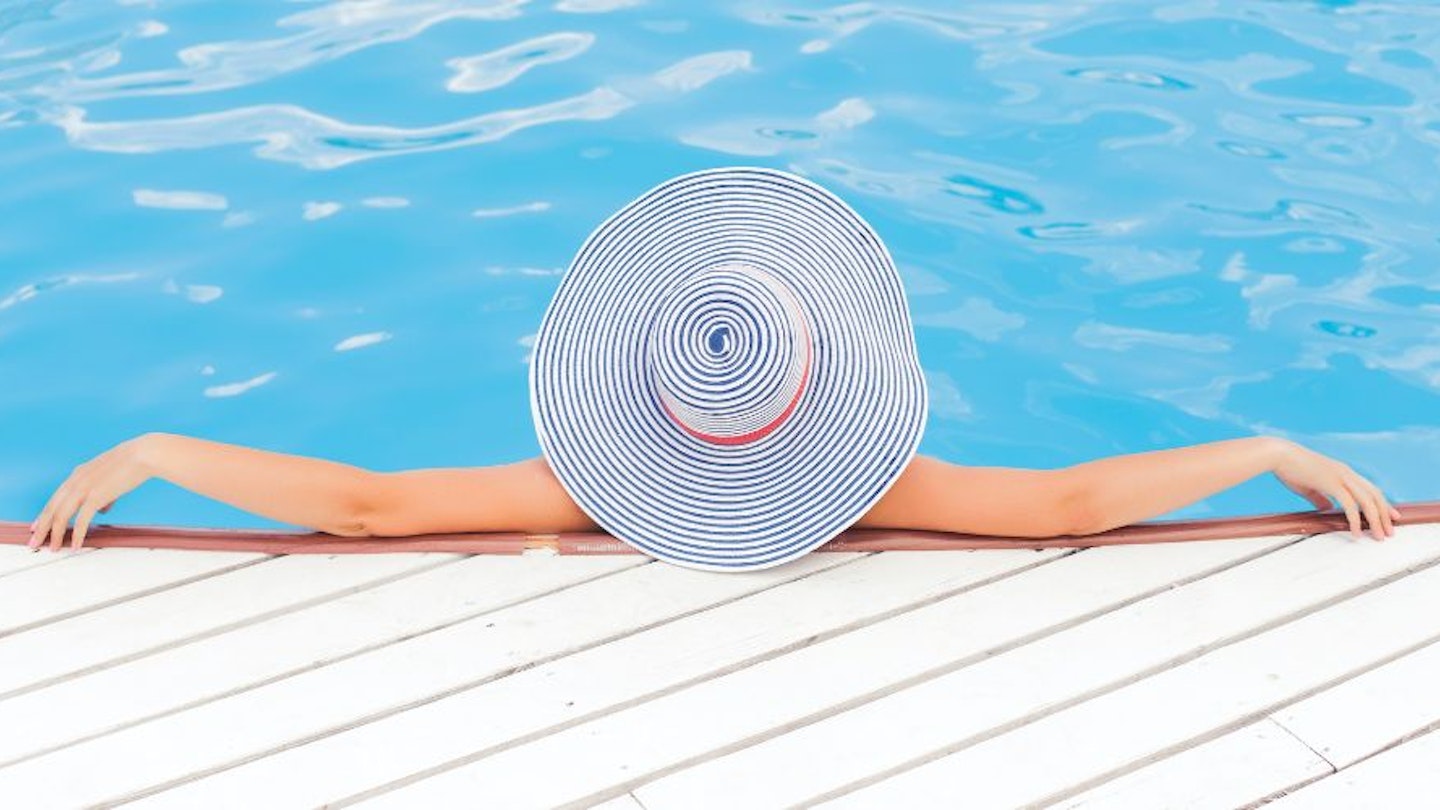 A women wearing a summer hat in a pool
