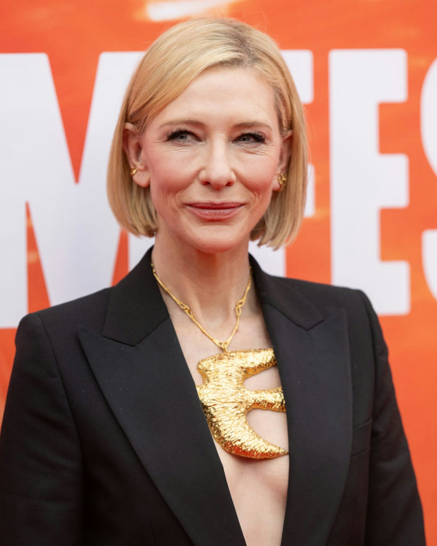 Cate Blanchett's sleek bob hairstyle paired with a black blazer and gold neck piece