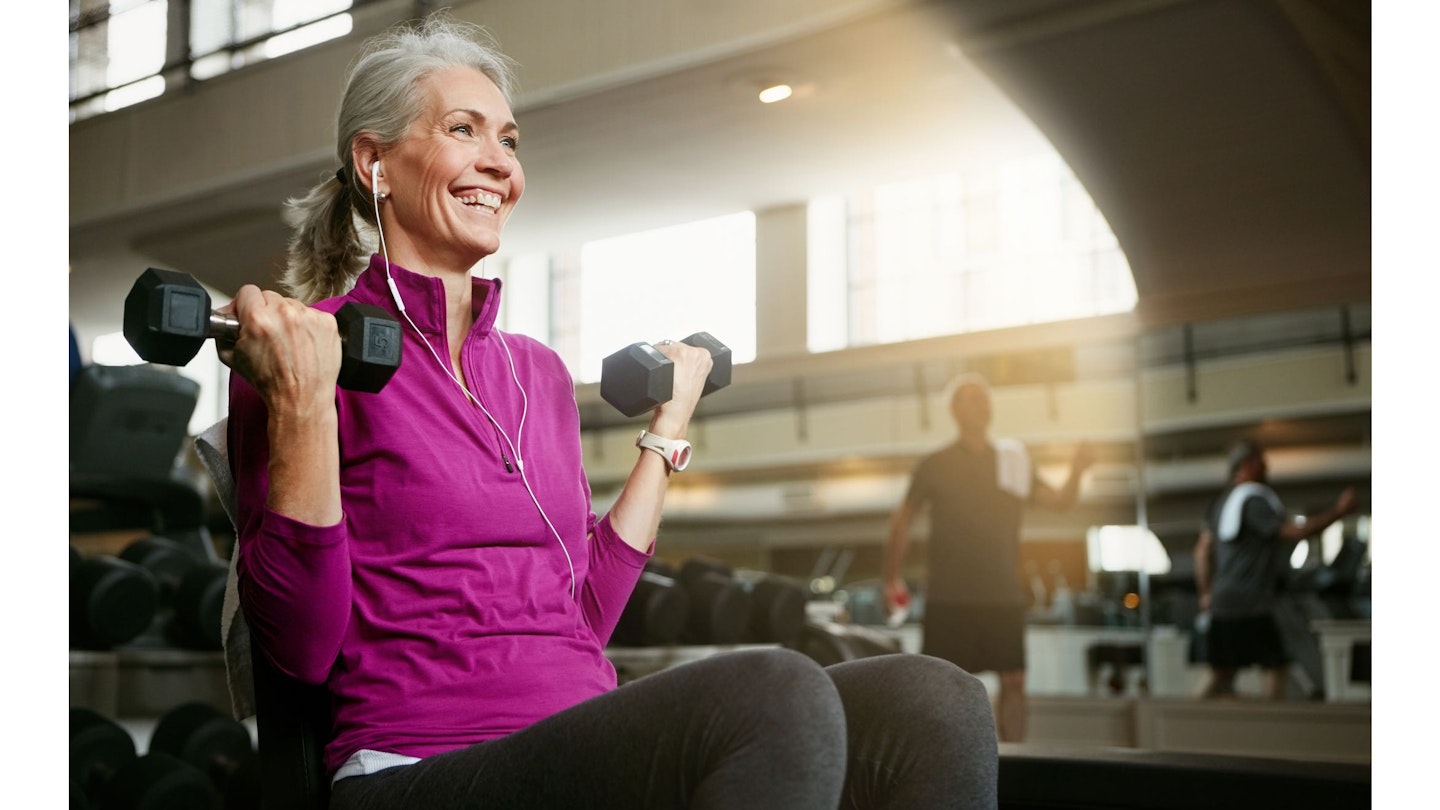 Woman doing a dumbbell bicep curl in a gym