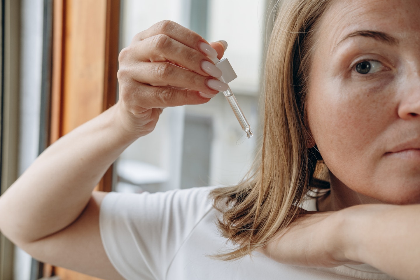 Woman using a pipette to apply hair oil