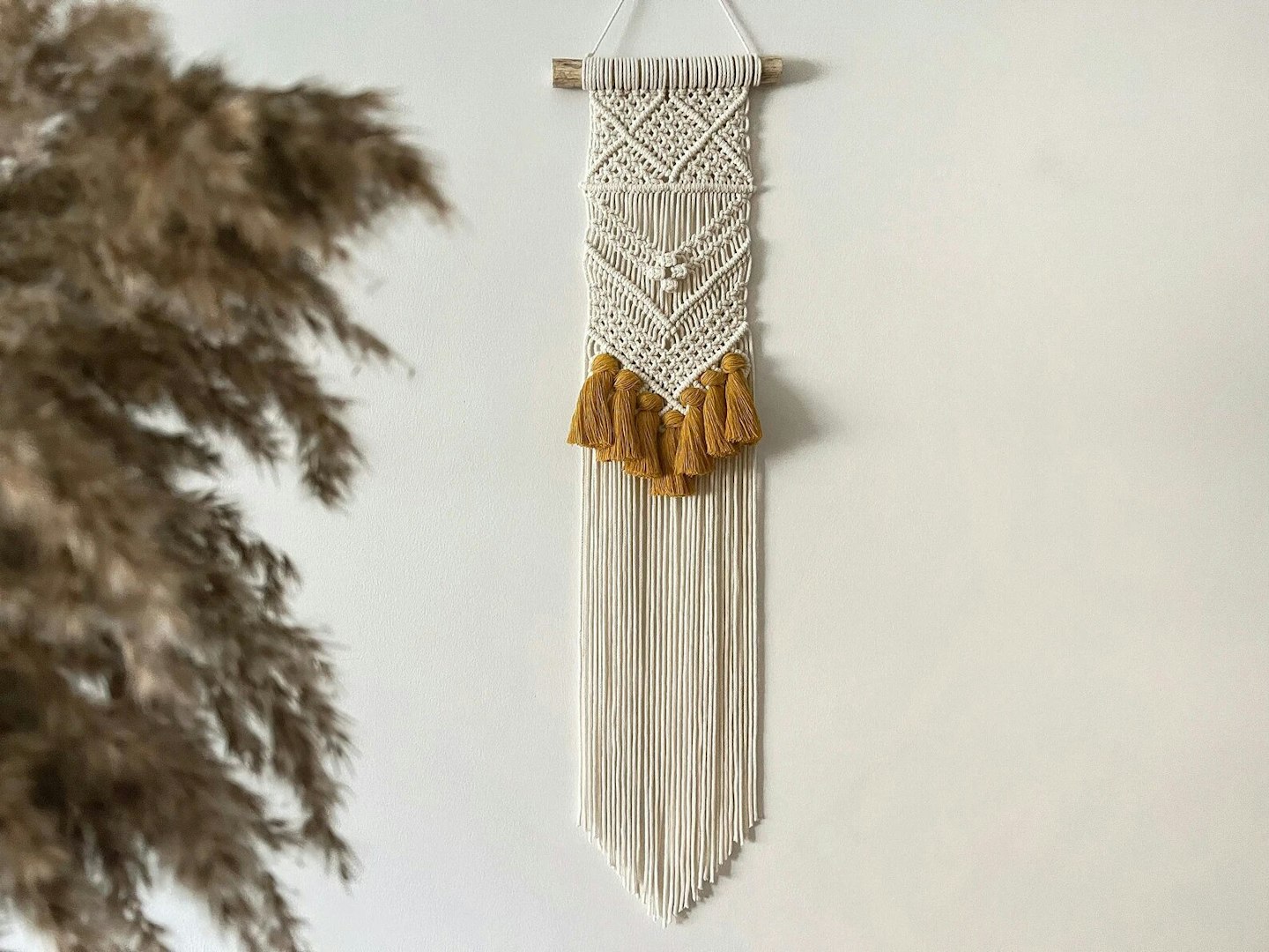 Narrow macrame wall hanging with mustard tassels