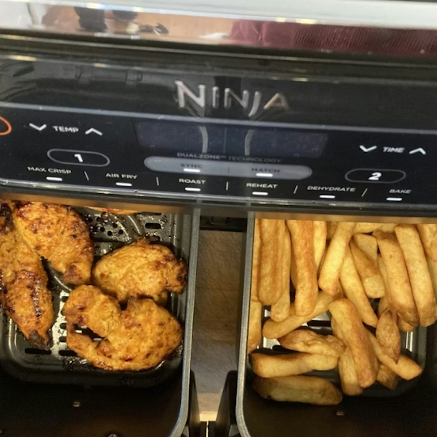 chicken in one compartment and chips in the other in the Ninja 7.6L Foodi Dual Zone Air Fryer and Dehydrator