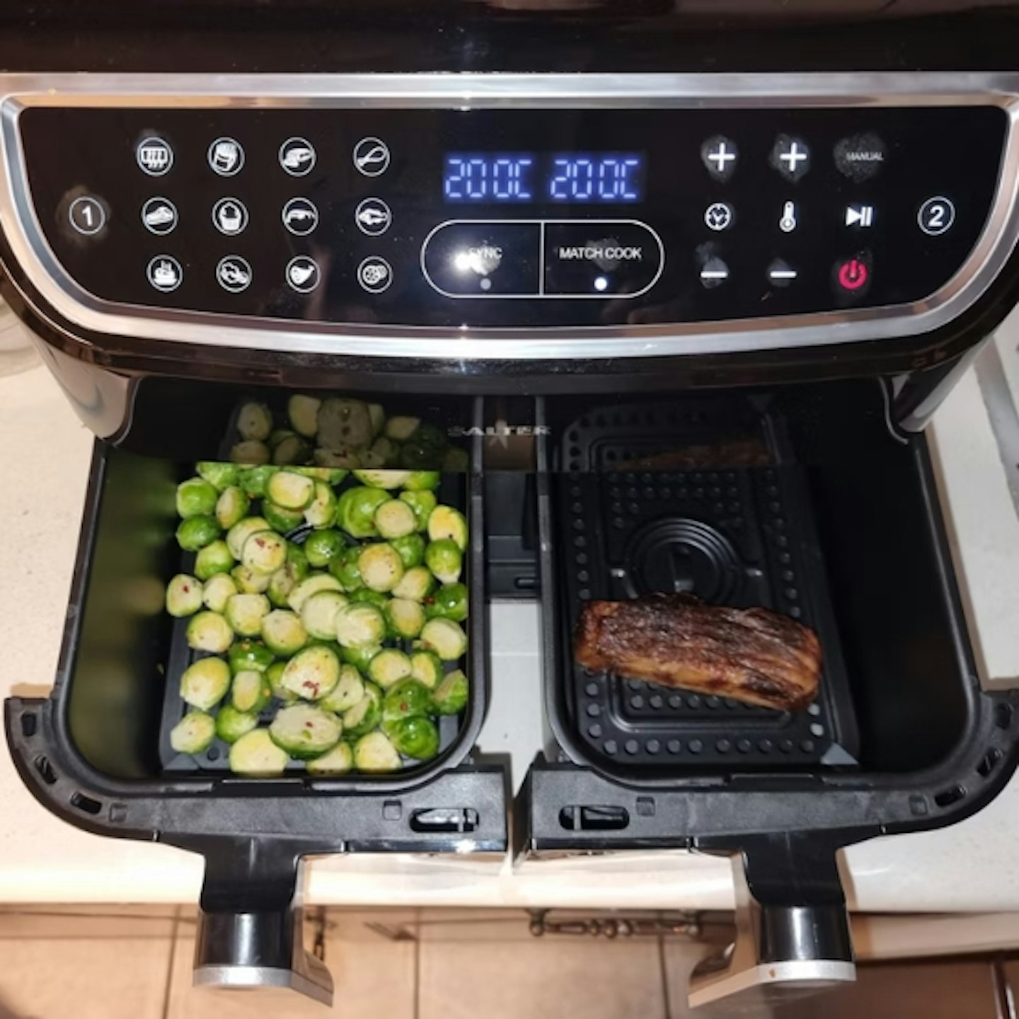 Salter Dual Cook Pro Air Fryer with both drawers open, on the left are chopped up brussel sprouts and on the right is some meat