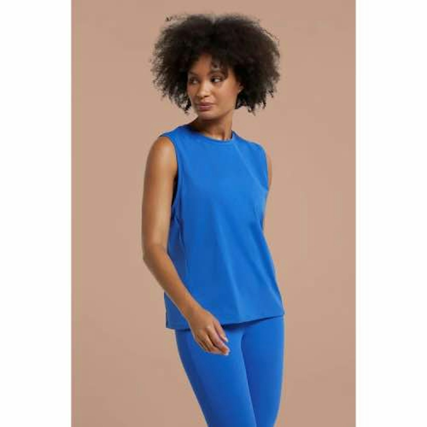 A lady wearing a right blue sleeveless top and leggings 