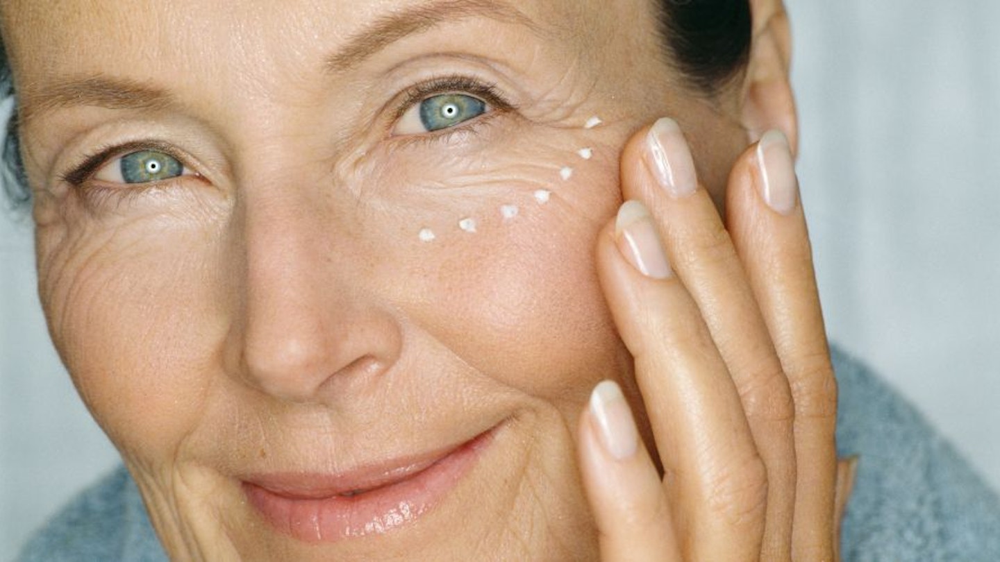 A lady applying eye cream under her eyes