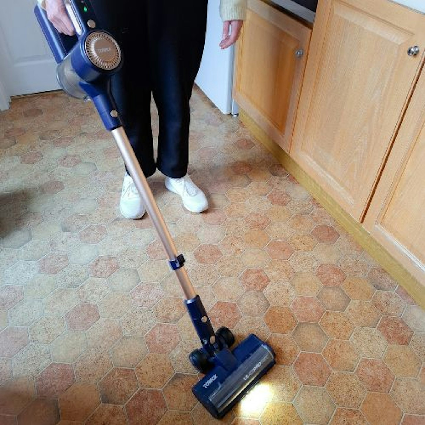 photo of tester using the Tower VL45 Pro Pet Anti Tangle Cordless 3-in-1 Pole Vacuum on a hard floor in a kitchen