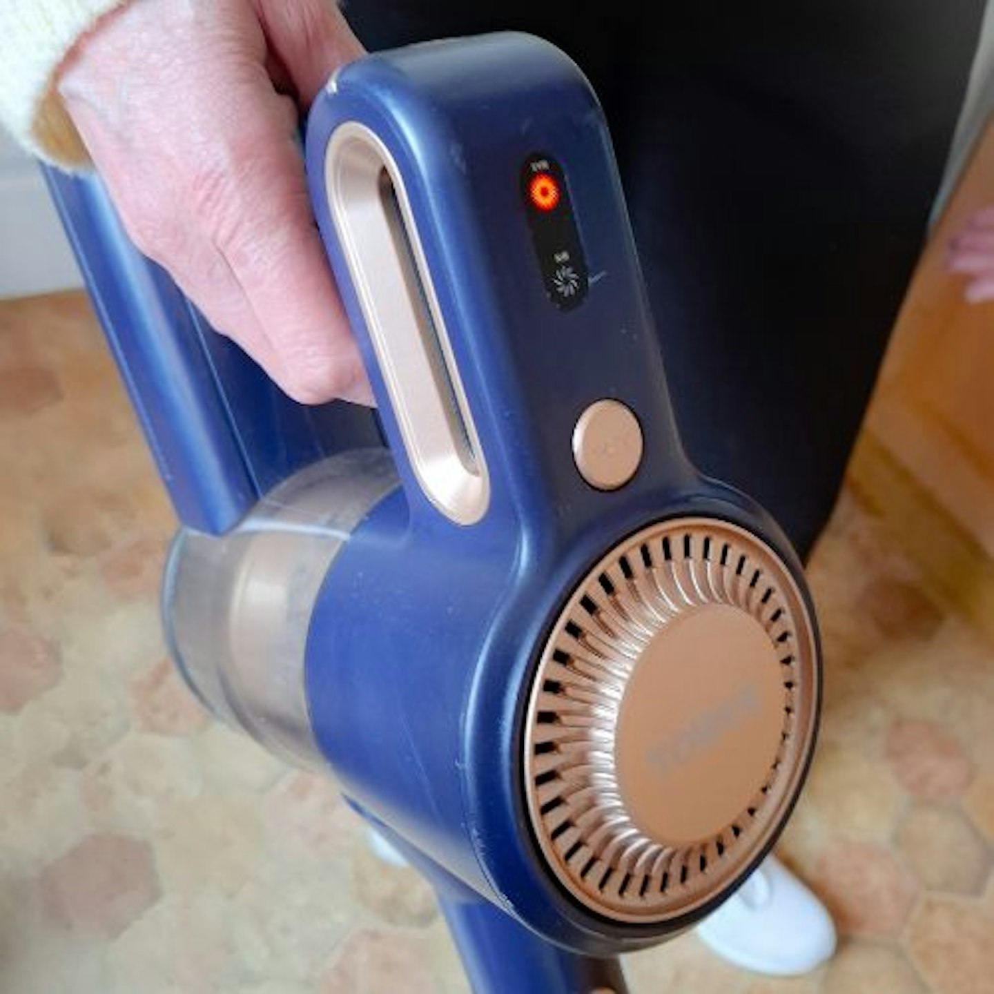 close up photo of the power button and front of the Tower VL45 Pro Pet Anti Tangle Cordless 3-in-1 Pole Vacuum in the tester's hand
