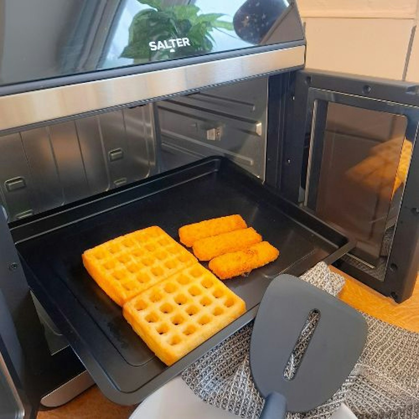 Air fried potato waffles and fish fingers in the Salter French-Door Style XL Air Fryer Oven