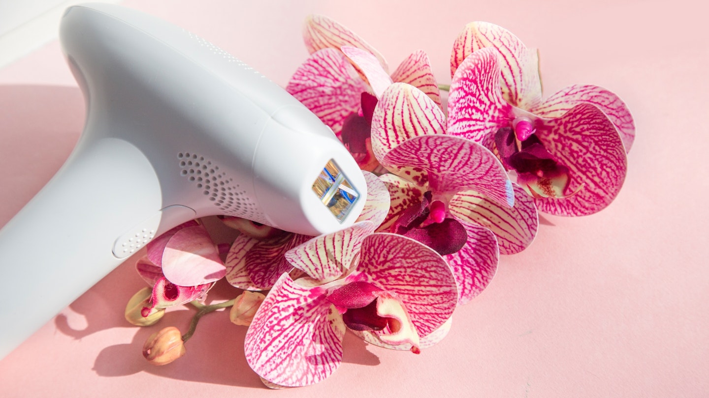 laser hair removal device with flowers on pink background