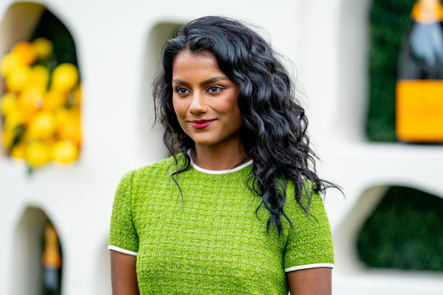 Photo of Simone Ashley with 2c wavy hair, in a lime green dress