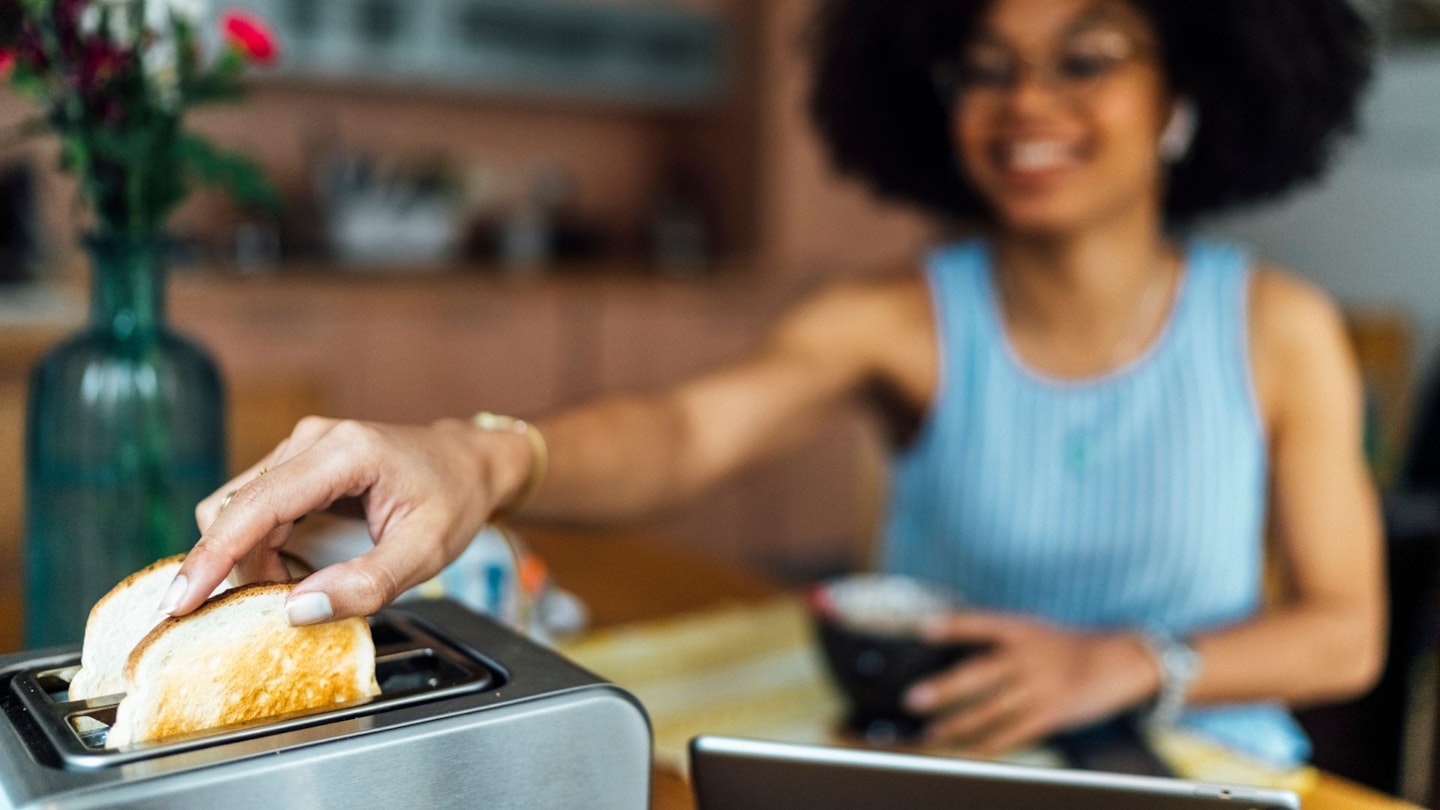 Woman using toaster