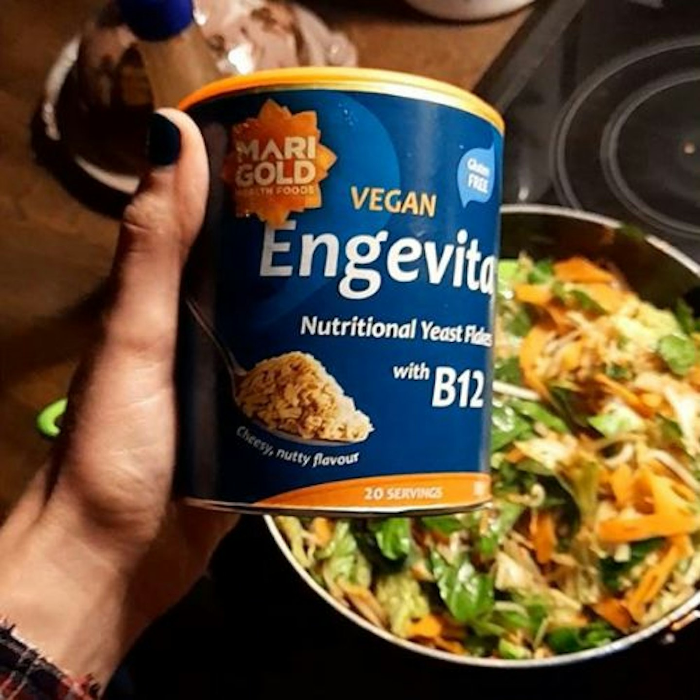 photo of Marigold Engevita B12 Yeast Flakes in tester's hand with a stir fry in the background