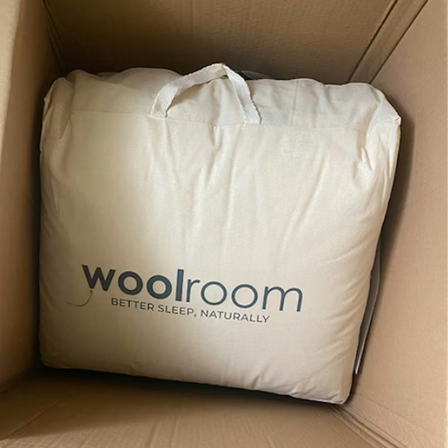 Woolroom Deluxe Washable Wool All Season Duvet in the packaging bag, sat inside the box