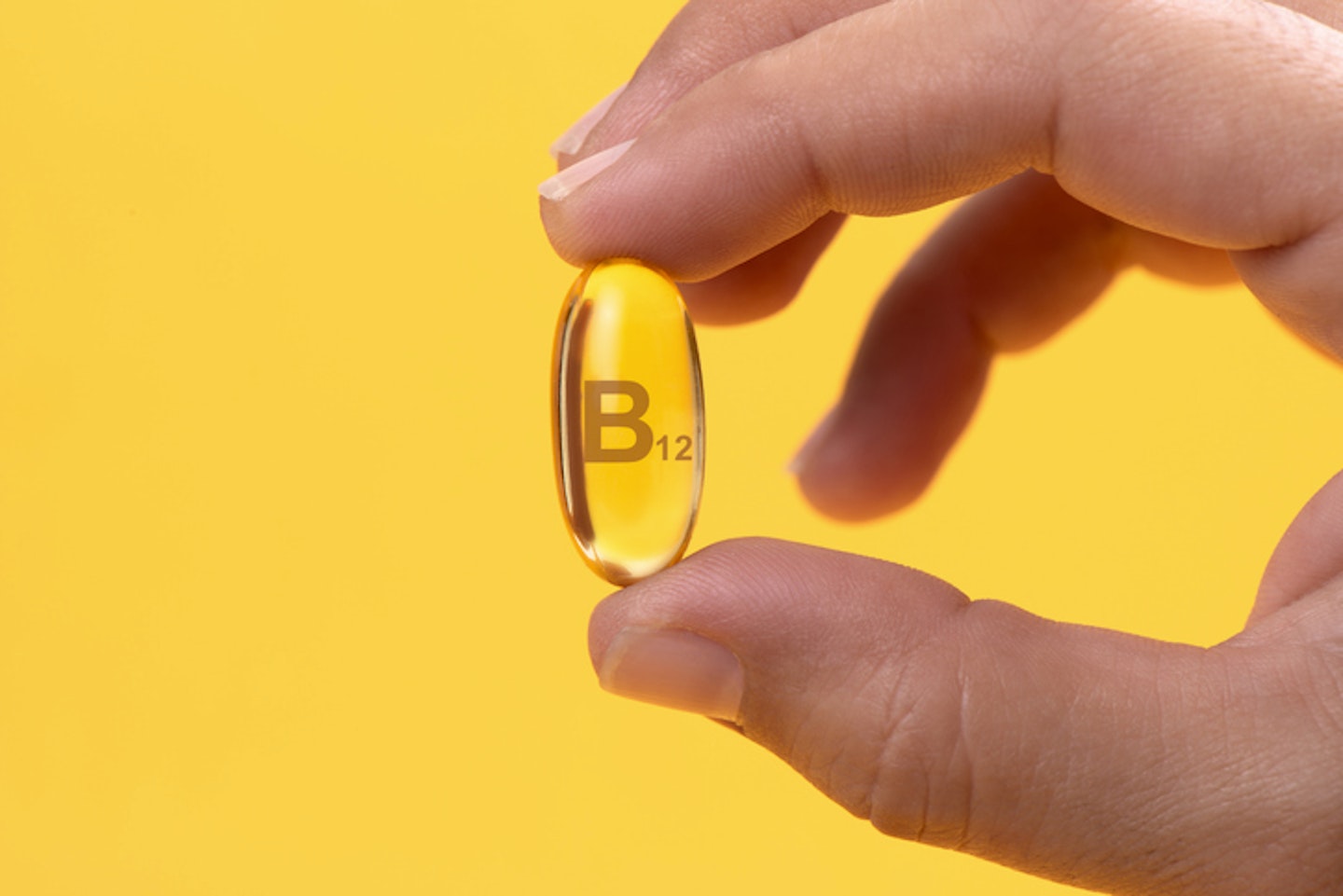 Hand Holding Vitamin B12 capsule