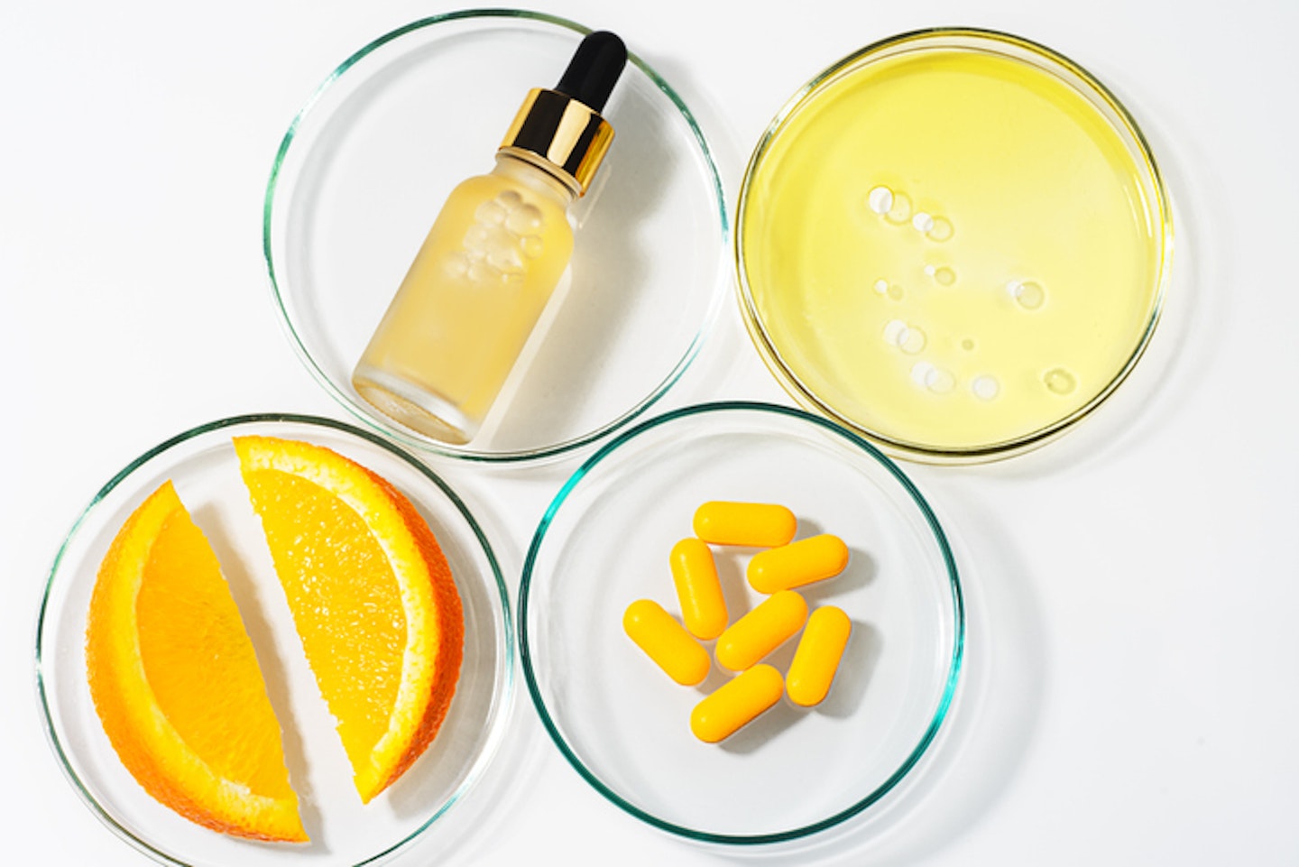 Beauty concept of Vitamin C serum in cosmetic bottle with dropper and slices of orange fruit.