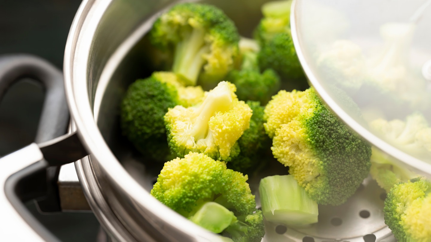 Freshly steamed broccoli in a stainless steel steamer combination pot.