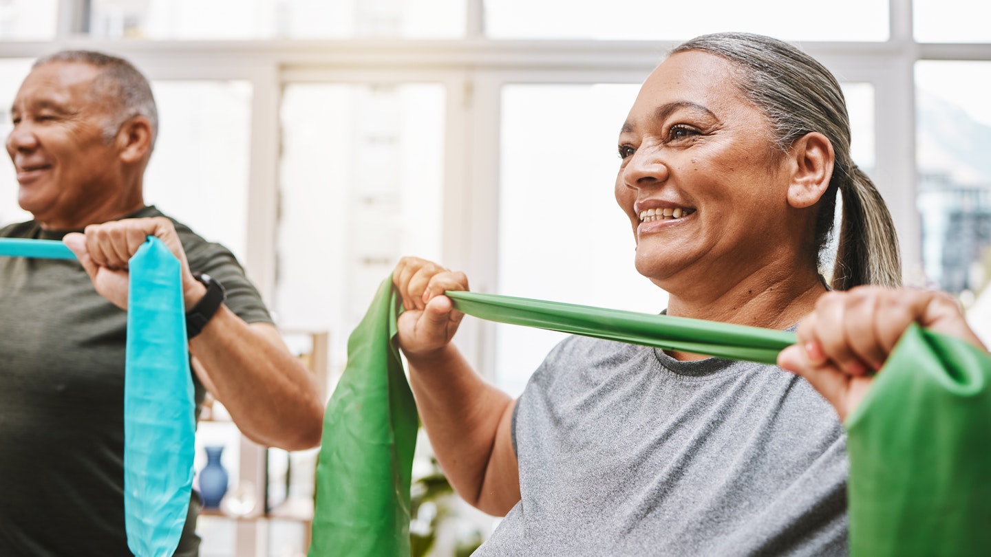 Couple using resistance bands to stretch chest