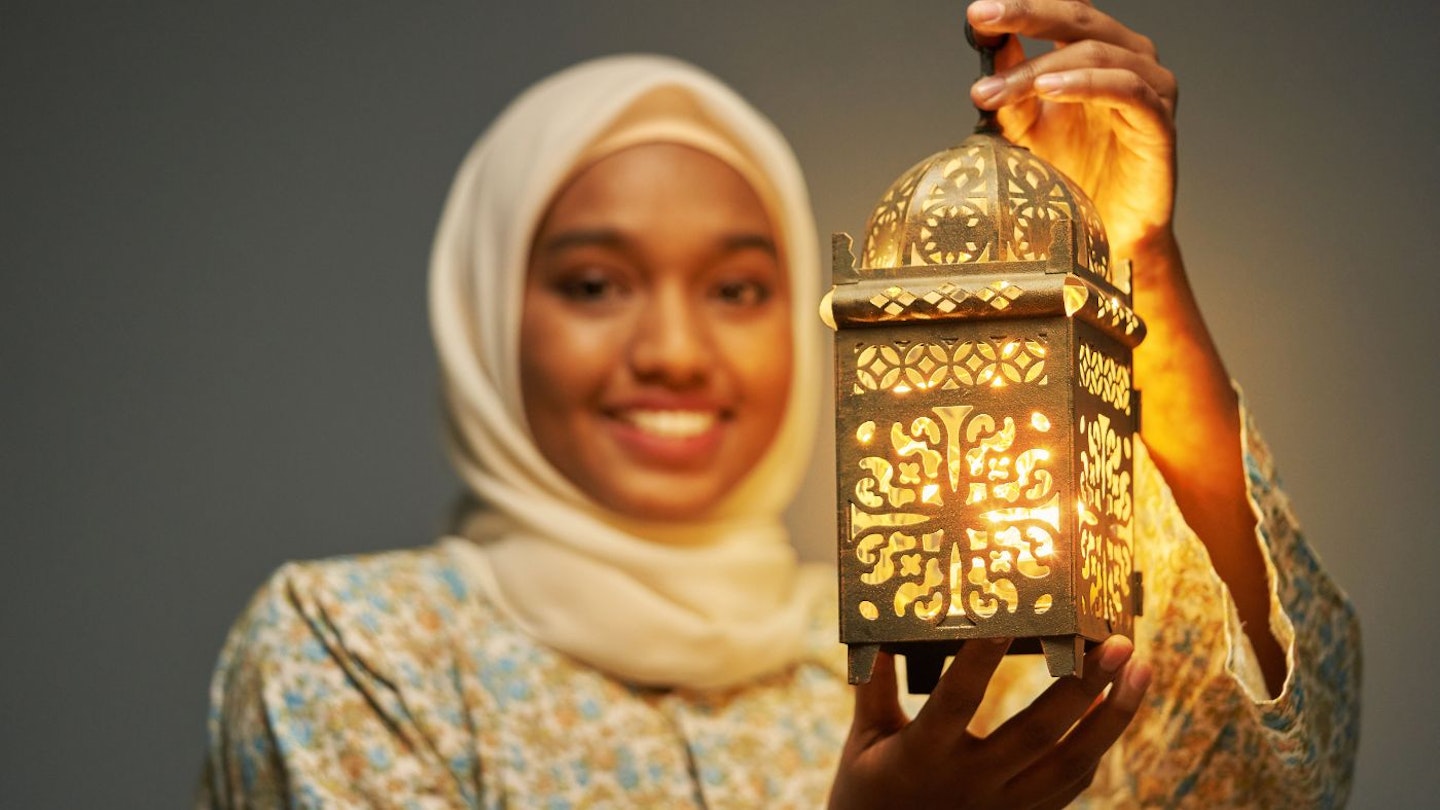 Woman wearing a hijab, holding a lantern (Ramadan décor idea)