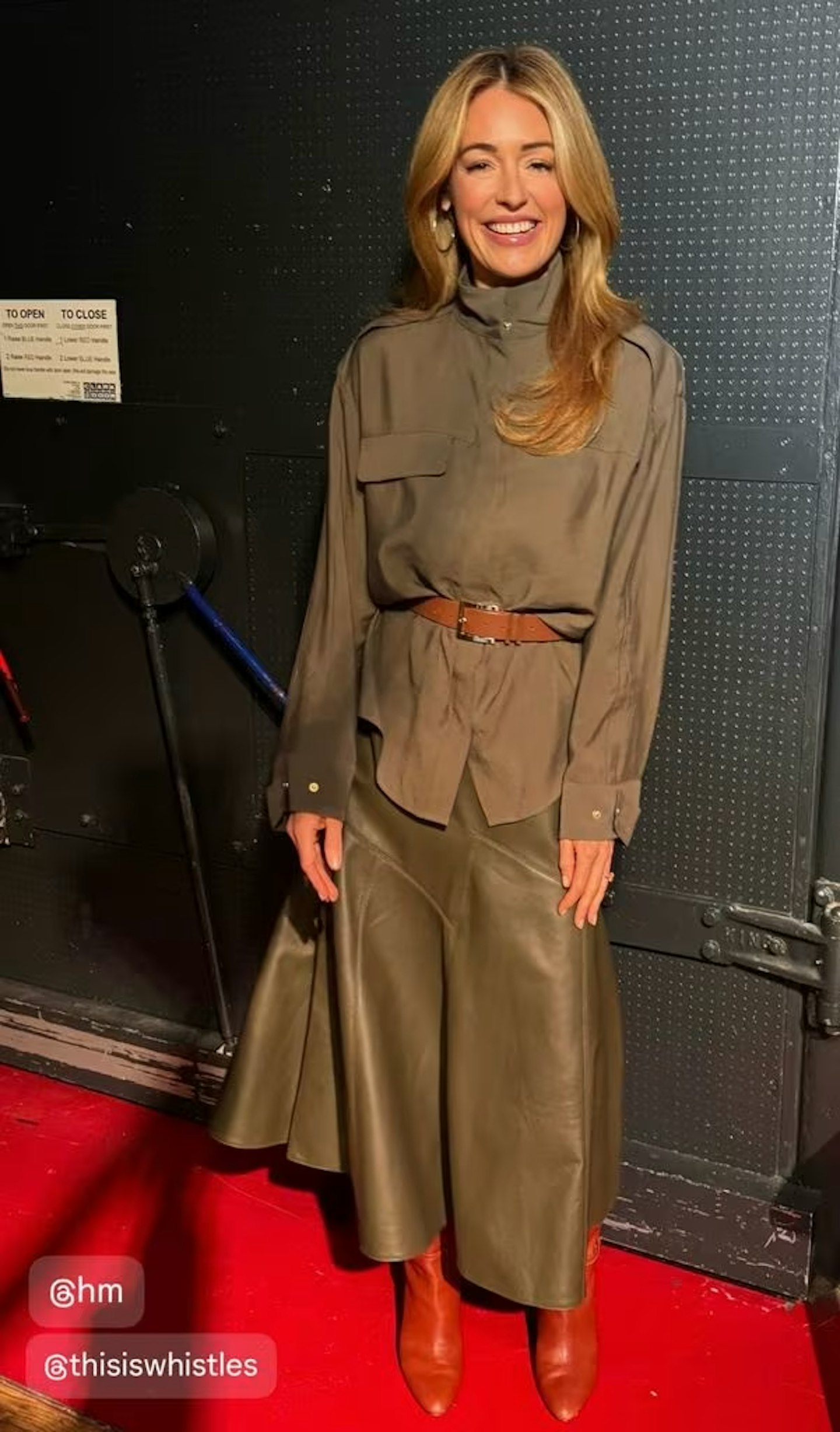 Cat Deely in a khaki blouse and skirt