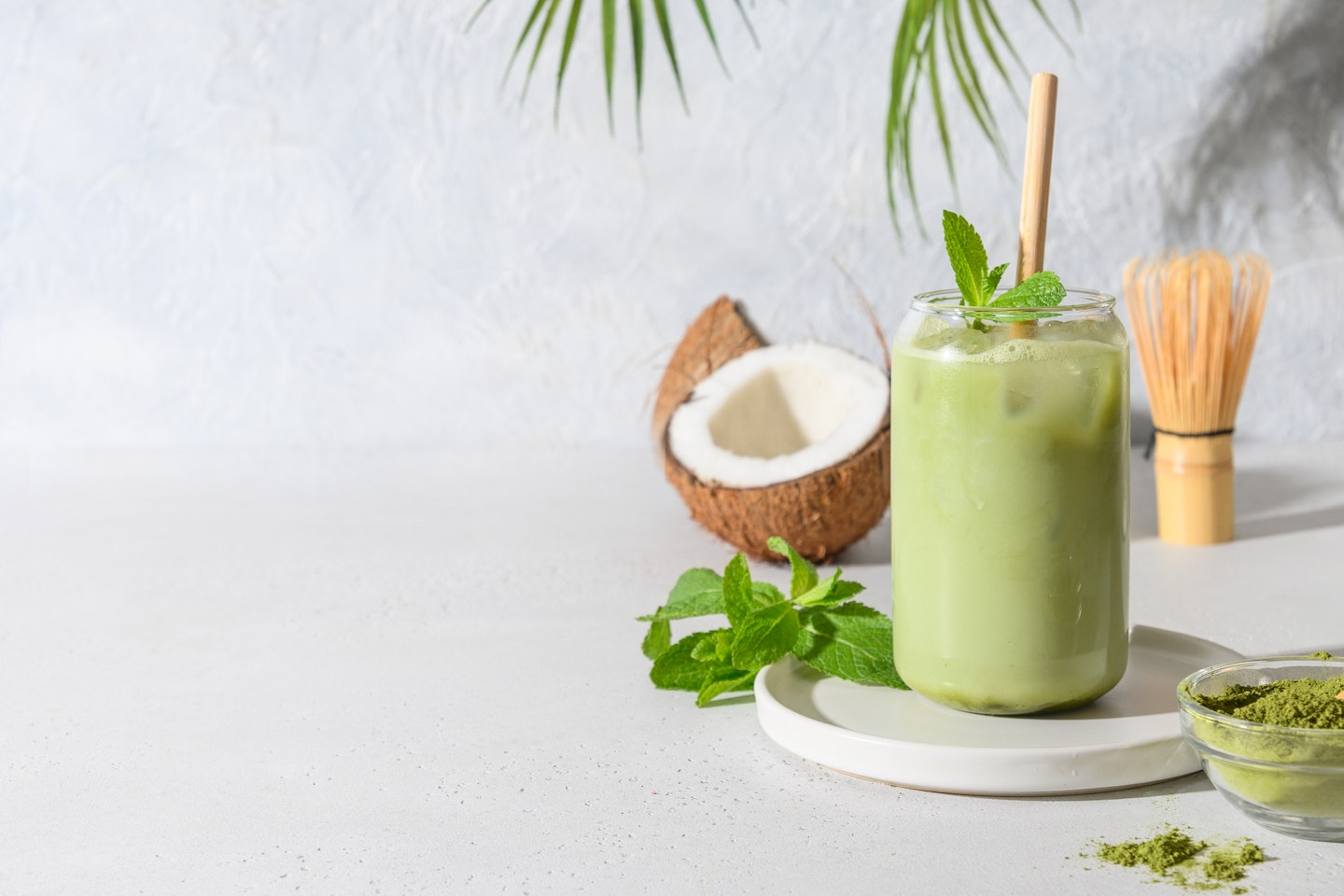 Iced Green matcha tea in glass garnish mint on white