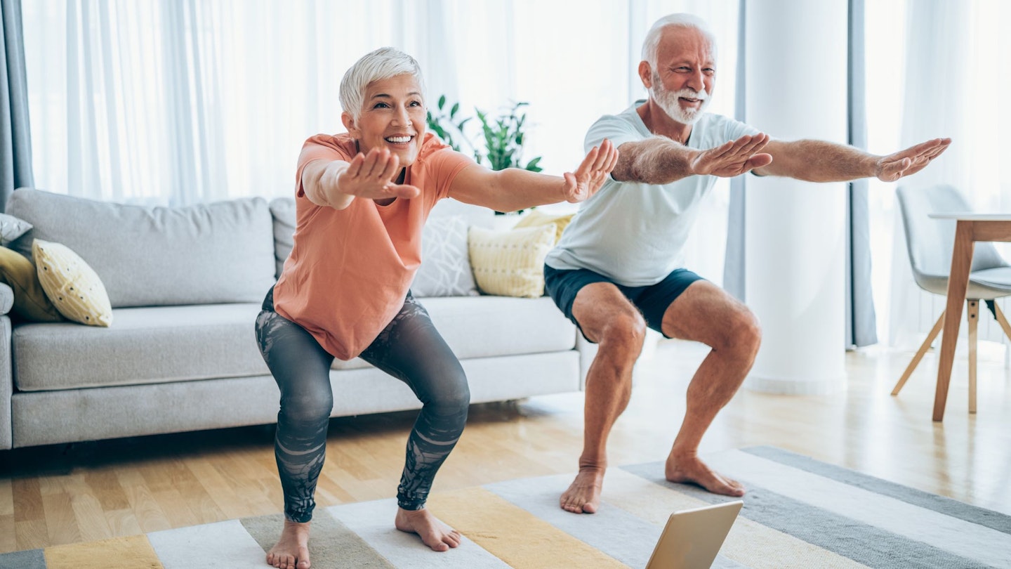 Man and woman doing a squat at home