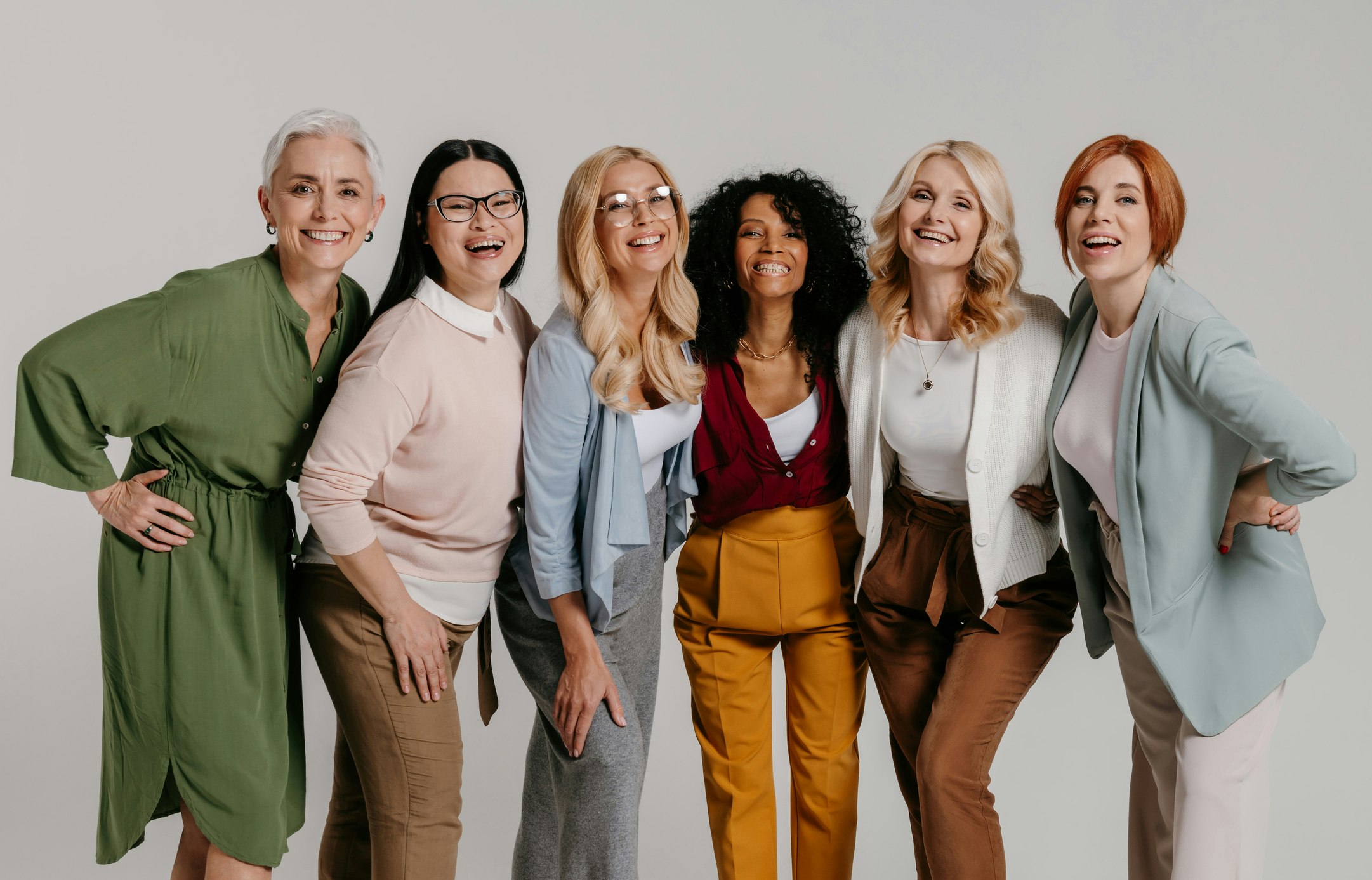 Multi-ethnic group of mature women against a grey background