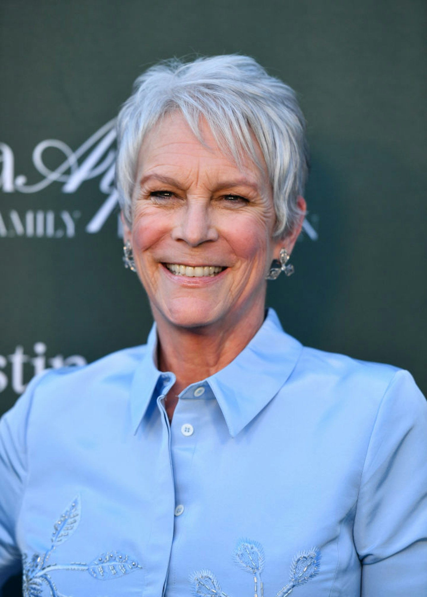 Jamie Lee Curtis with her spiked crop haircut and a blue shirt