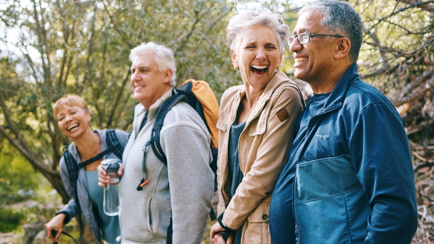 Four friends hiking together and laughing 2 female 2 male