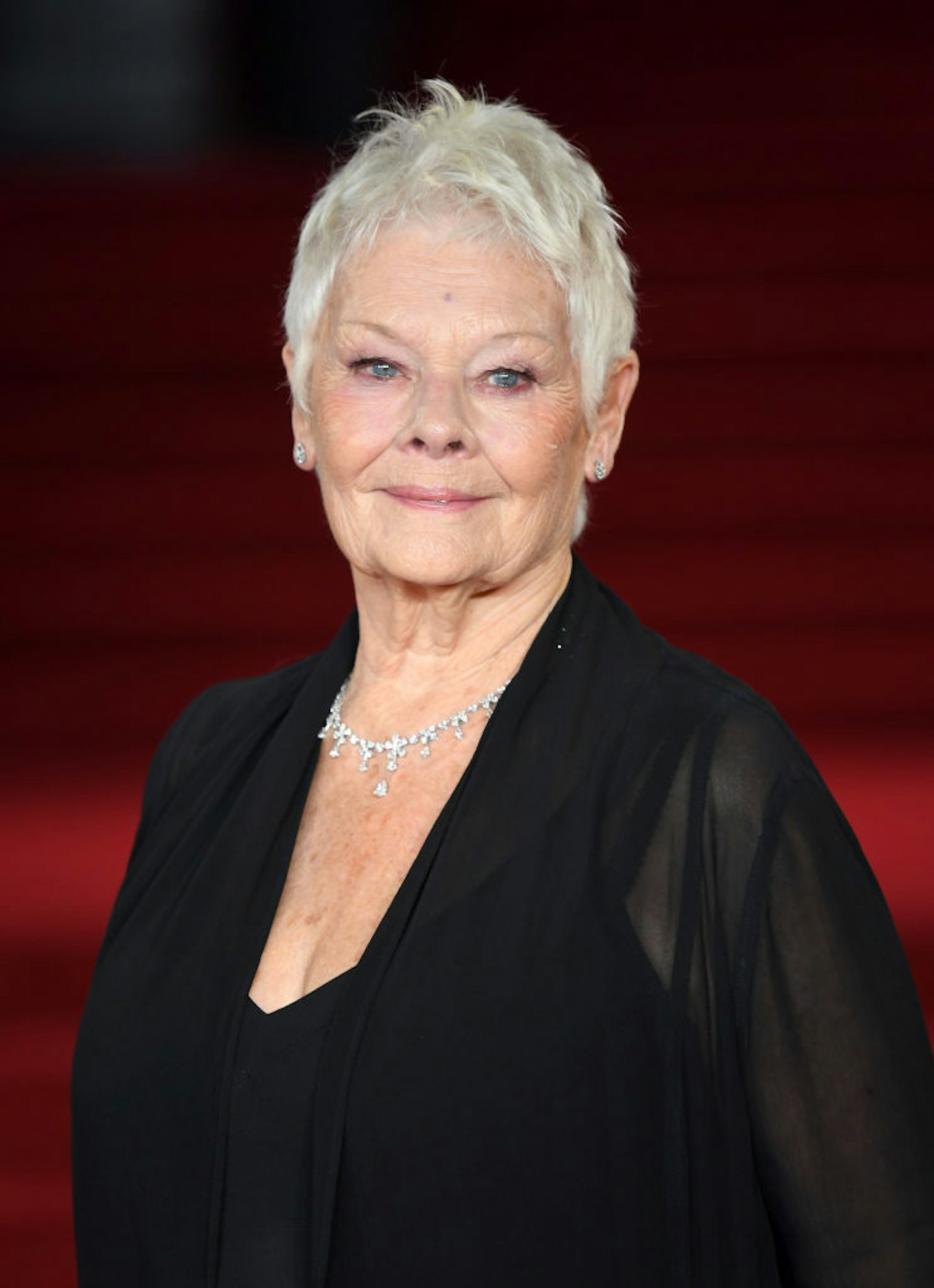 Judi Dench in a black dress and a crop haircut