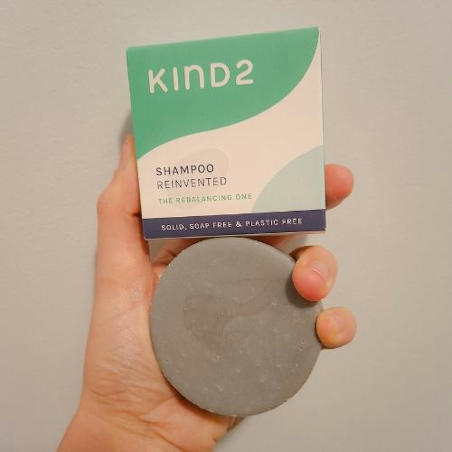 Kind2's 'Rebalancing One' shampoo soap bar and packaging in a tester's hand