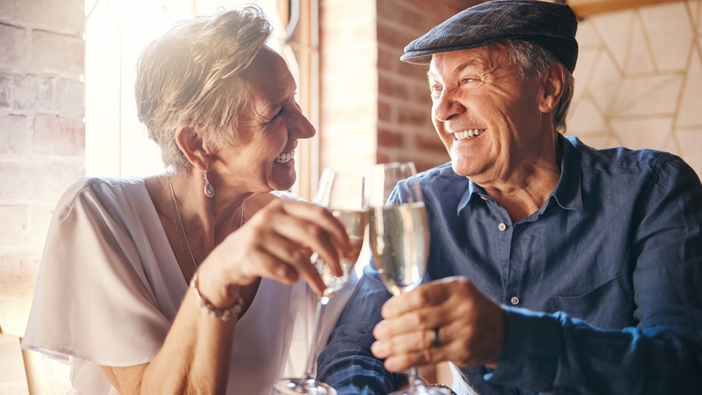 Male and female couple chinking glasses