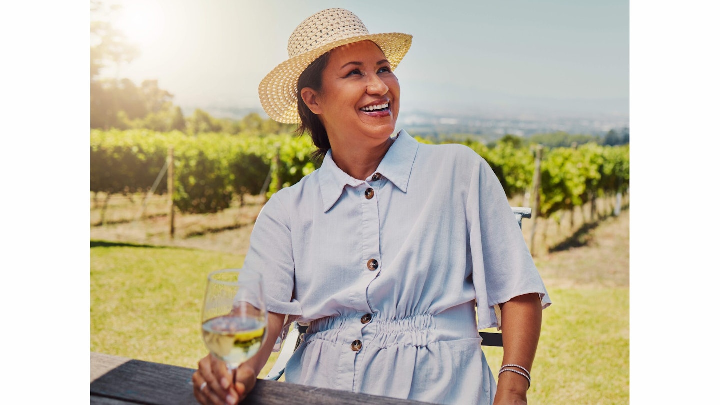 Happy woman in hat with glass of water