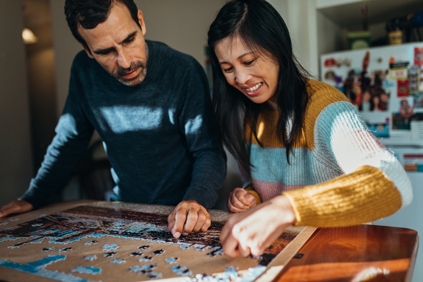 A couple using a puzzle board to solve a jigsaw puzzle