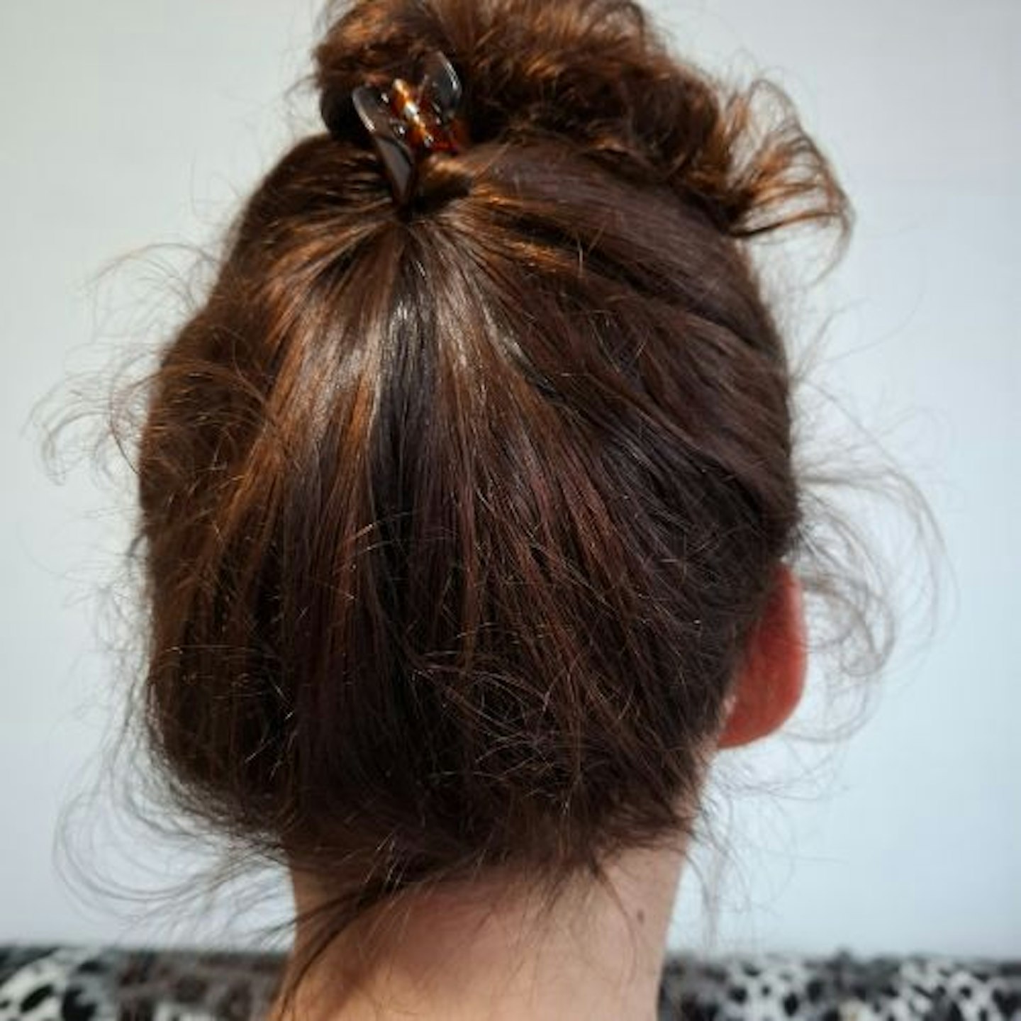 Back of tester's head showing shiny brown hair clipped up 