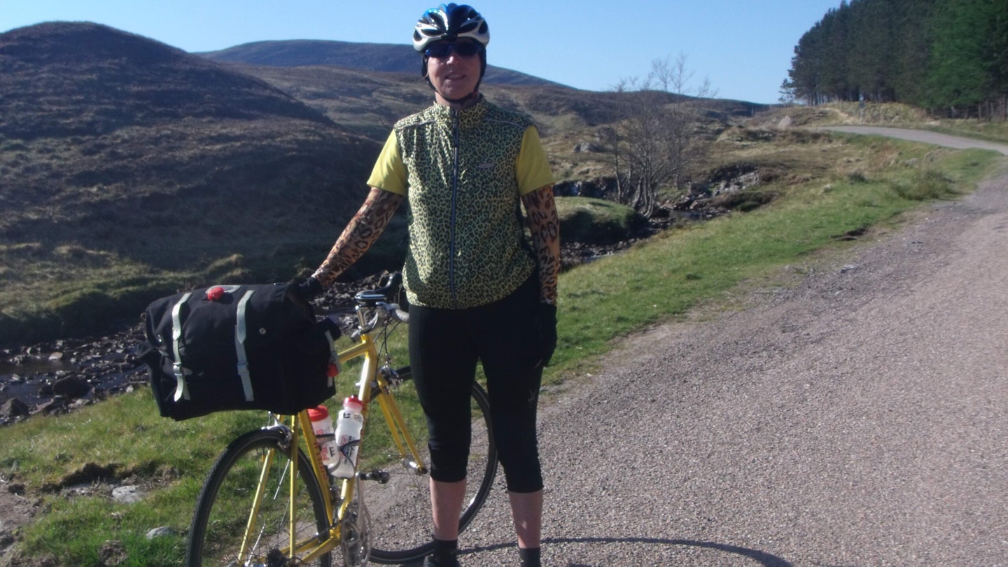 Jane Thurnell-Read with her bike at the top of a mountain