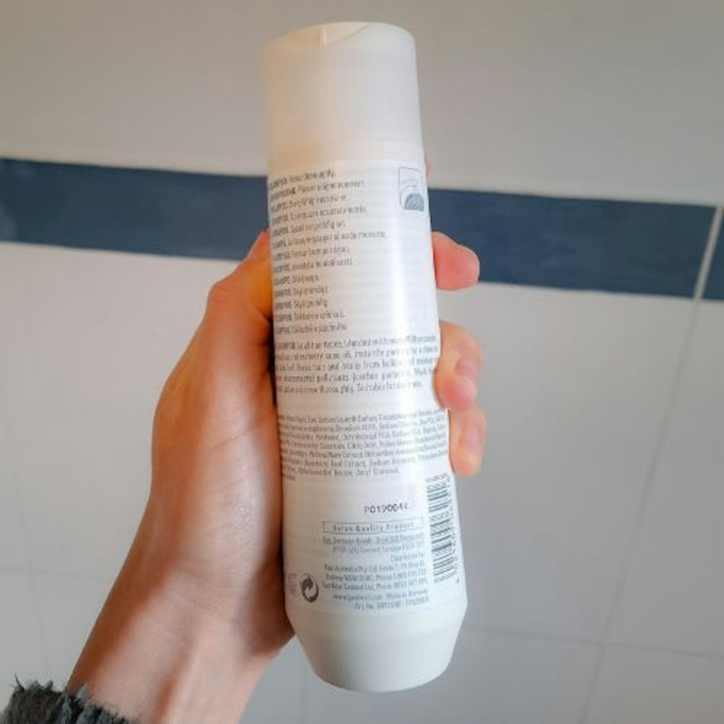 Back of the bottle of Goldwell Dualsenses Scalp Specialist Densifying Shampoo in tester's hand