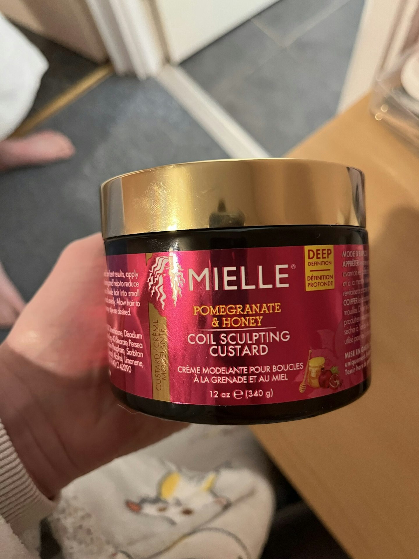 Image of our tester holding the Mielle Pomegranate & Honey Coil Sculpting Custard Hair Styling Gel 