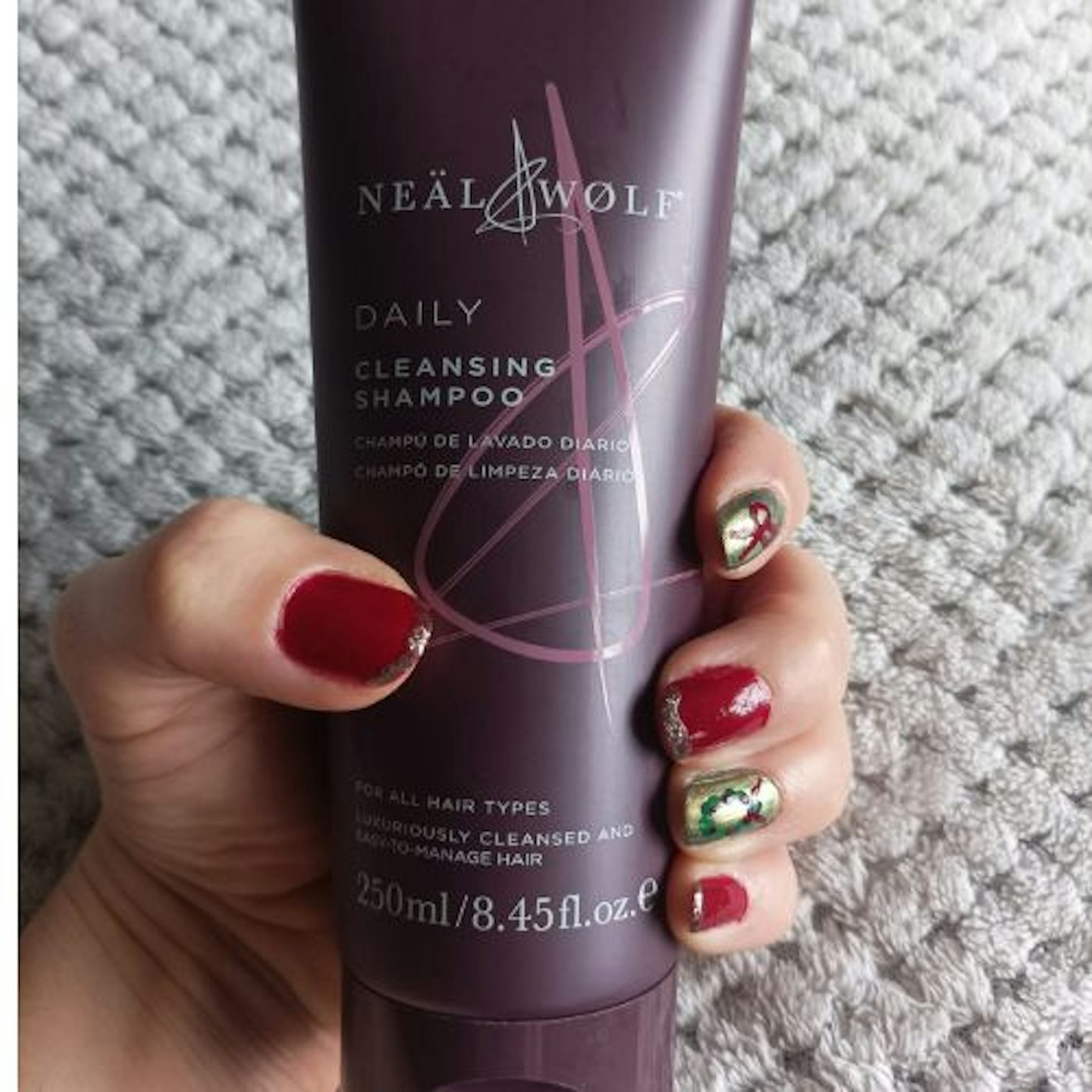 Tester holding a bottle of Neal & Wolf Daily Cleansing Shampoo