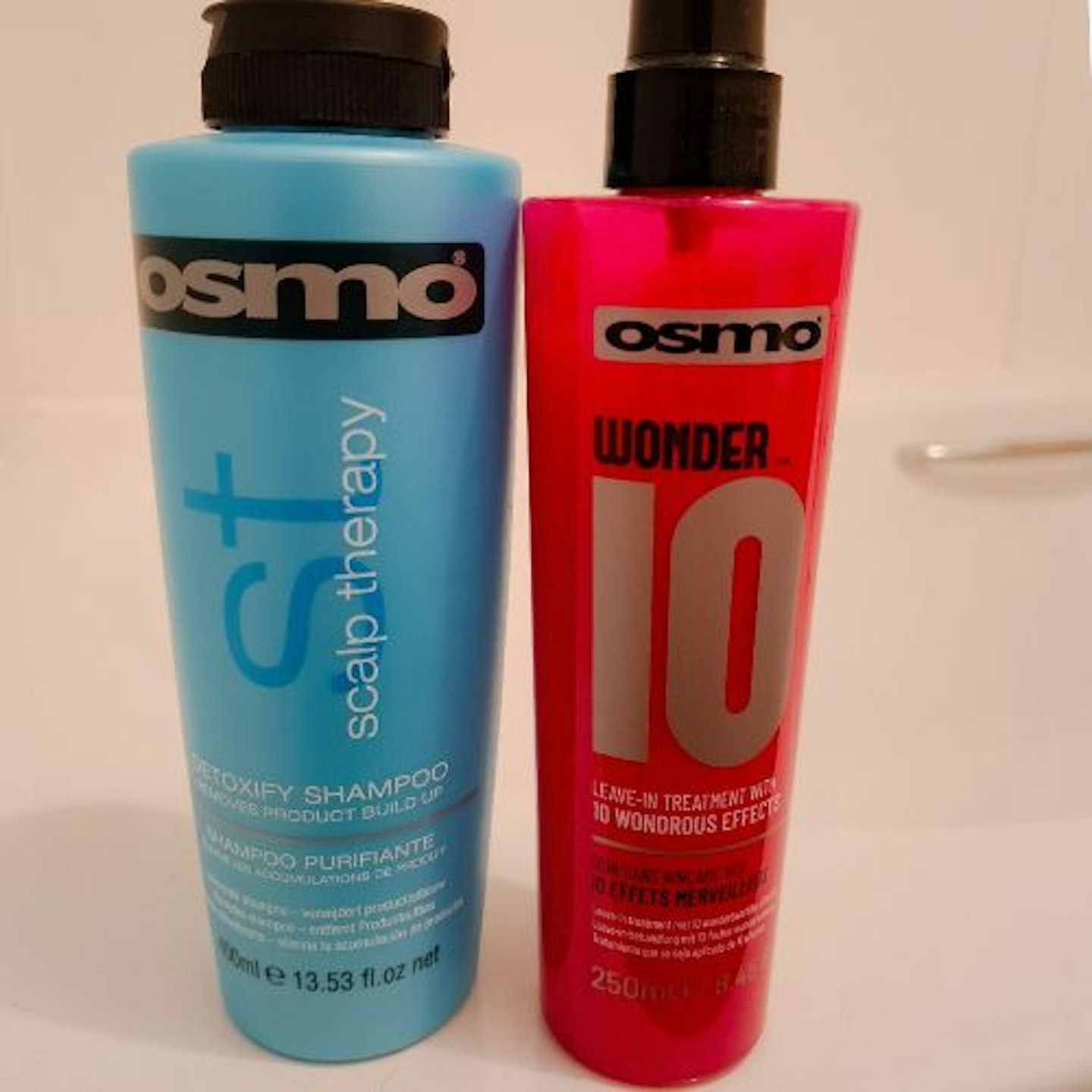 photo of OSMO Wonder 10 Leave-In Conditioner bottle beside OSMO Scalp Therapy Shampoo in a bathroom