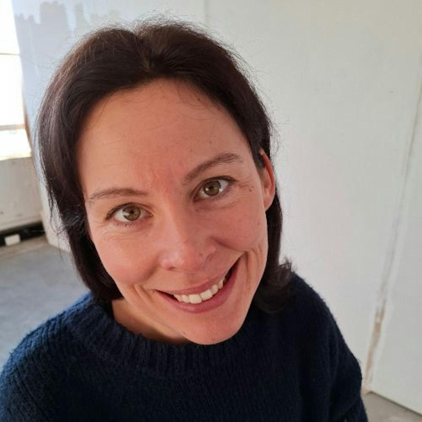 Natalie Knowles, close up of face and straight dark brown hair, white wall background