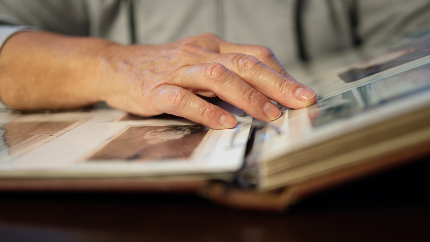 Old woman looking at family photo album