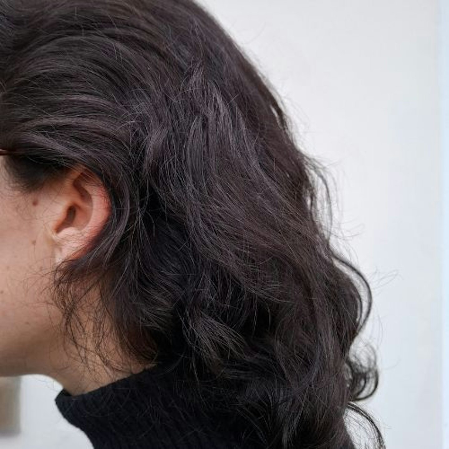 side view of tester's unstyled dark brown wavy hair