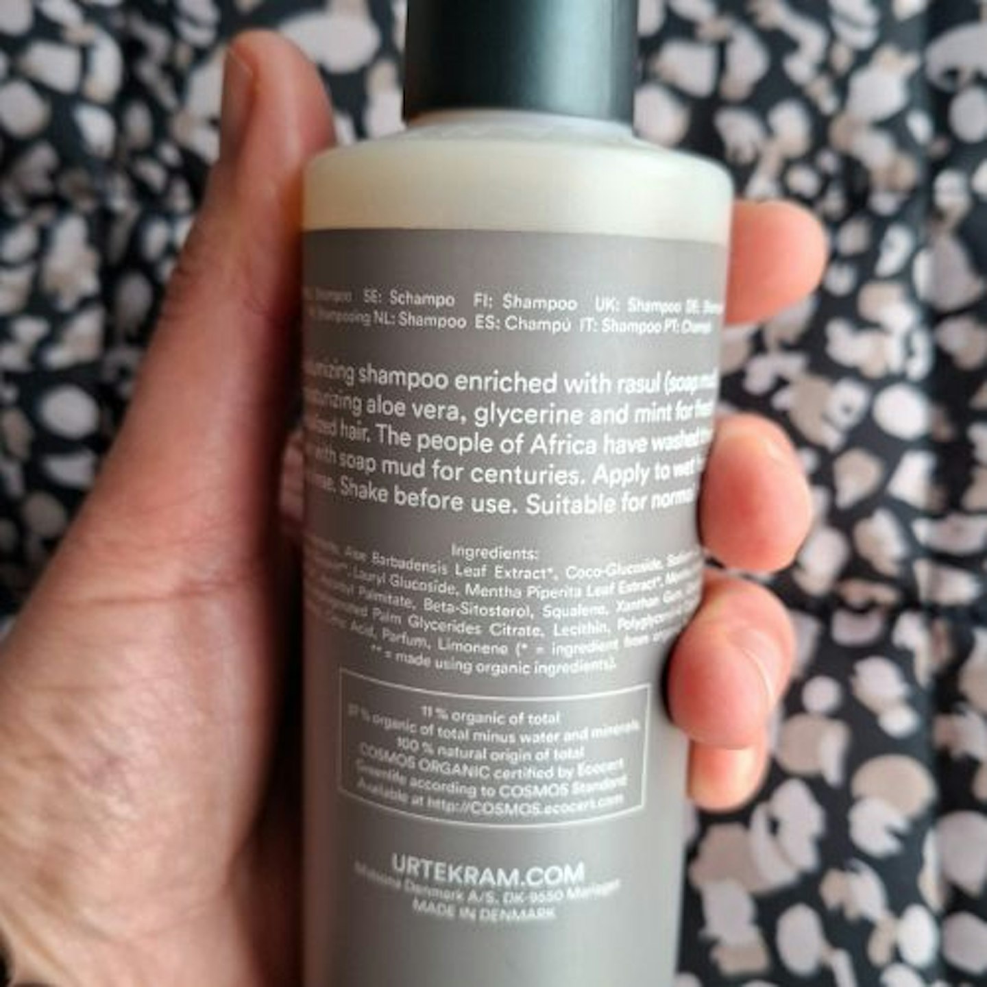 close up of back of bottle information of the Urtekram Organic Rasul Shampoo in tester's hand