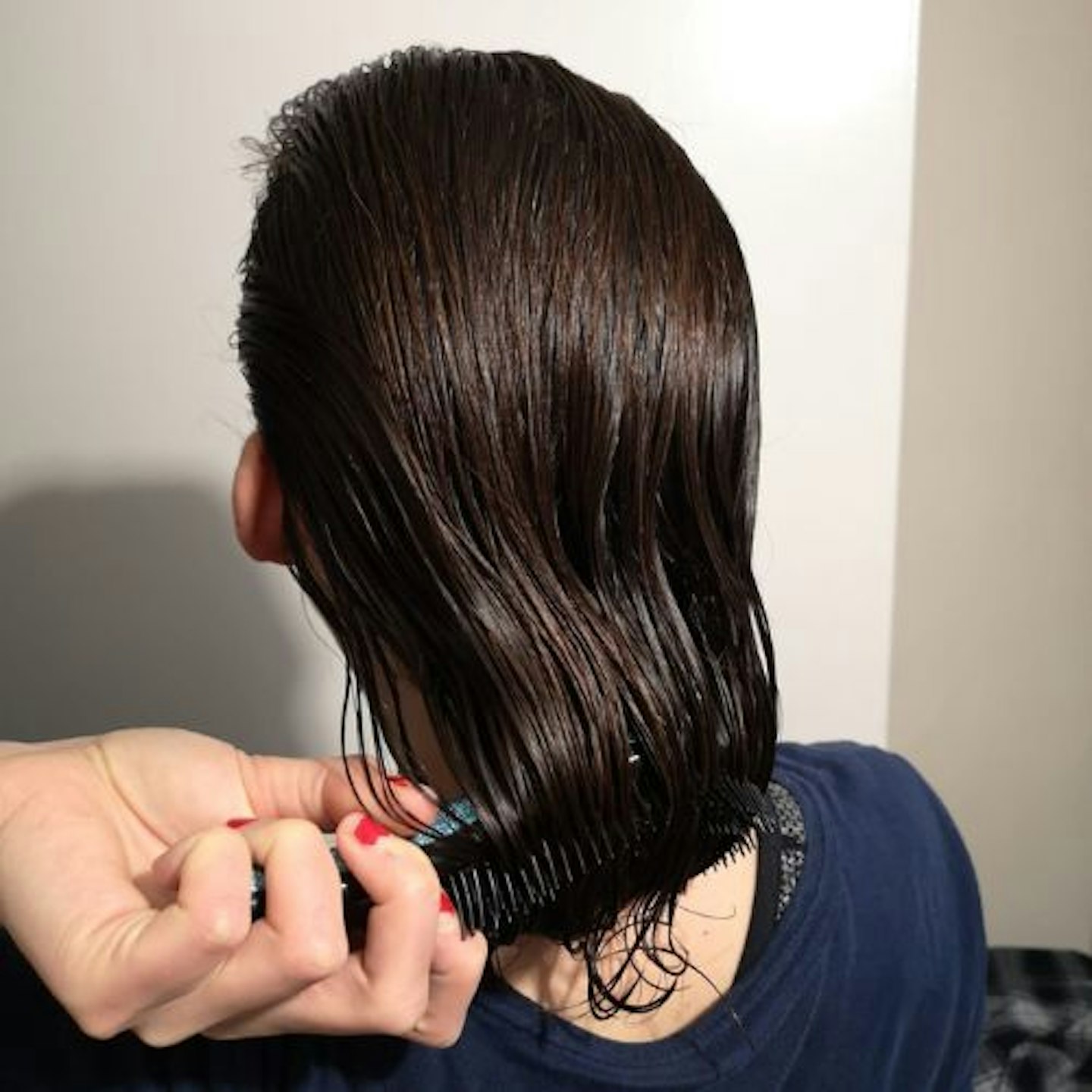 Tester, back view of head, damp brown hair being brushed 