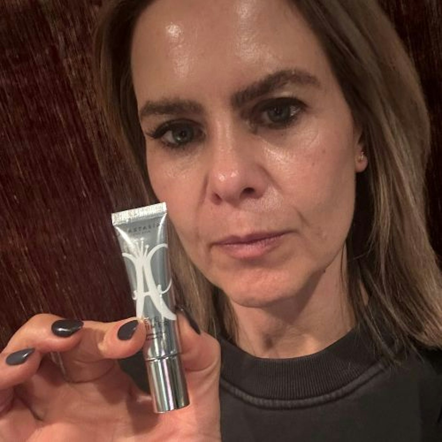 Suzanne wearing and holding the Anastasia Beverly Hills Mini Eye Primer