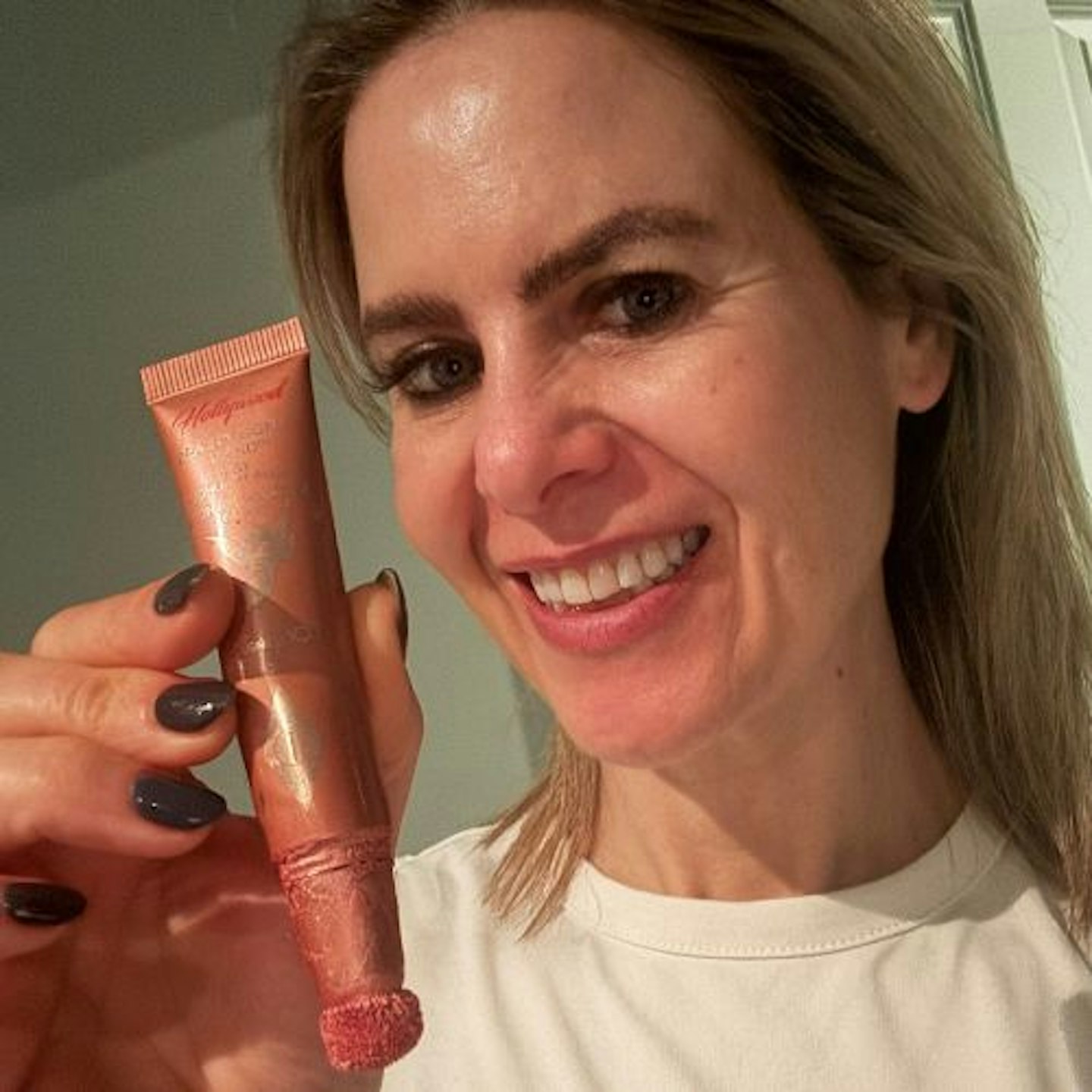 Suzanne wearing the Charlotte Tilbury Hollywood Contour Wand and holding the product up to her face