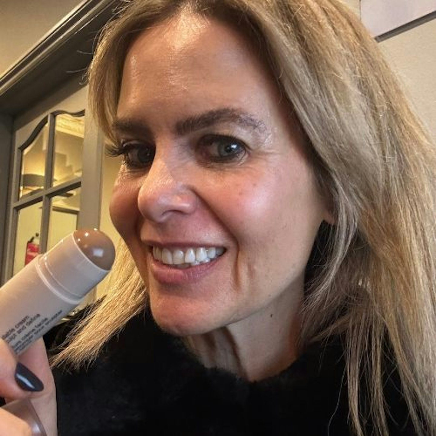 Suzanne holding up and wearing the SEPHORA COLLECTION Cream - Contour Stick